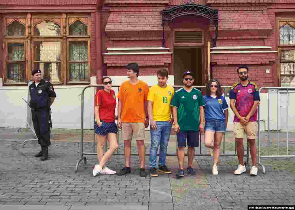 The activists near a Russian policeman. The officer may have been wondering what a Dutch fan is doing in Russia -- Holland failed to qualify for the 2018 World Cup.