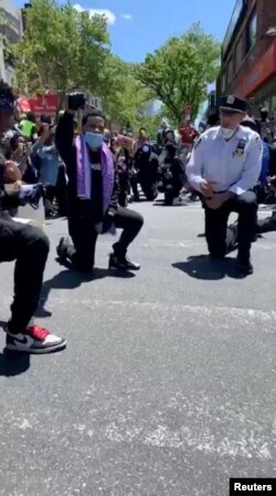 New York, polițist în genunchi, în semn de solidaritate cu protestatarii, 31 mai 2020.