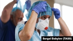 A medical worker puts on personal protective equipment amid the coronavirus outbreak, at a federal clinic in Moscow. 