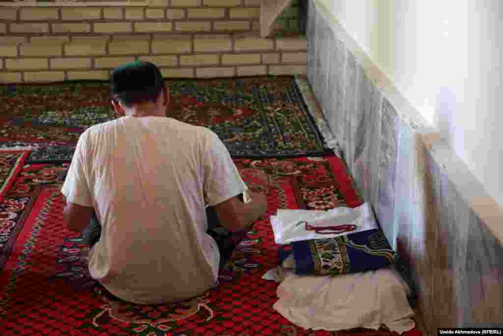 Смотритель мавзолея &quot;Аулие ата&quot; Нухритдин читает Коран паломникам.