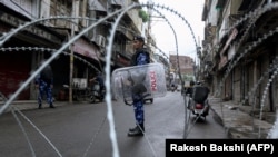 Rapid Action Force personnel stand guard at a roadblock ahead of the Muslim Friday noon prayers in Jammu on August 9.