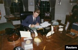 Președintele Statelor Unite, John F. Kennedy, semnând la Casa Albă, pe 3 Octombrie 1962, interdicția de a fi aduse în Cuba arme ofensive, în timpul „crizei rachetelor”.
