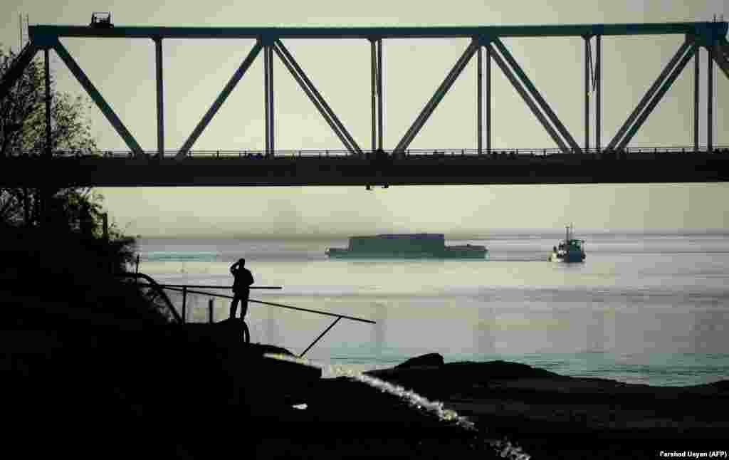 An Afghan man watches a ship travel along the Amu River on the border of Afghanistan and Uzbekistan, about 75 kilometers north of Mazar-e Sharif. (AFP/Farshad Usyan)