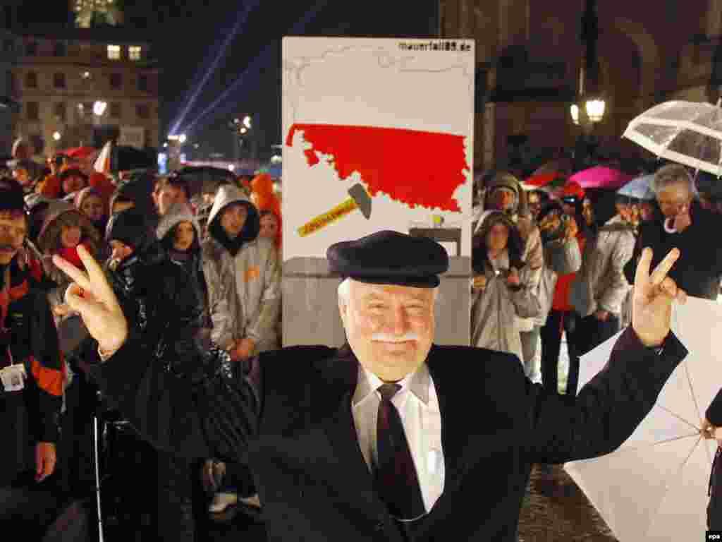 Walesa posing in front of a symbolic Berlin Wall domino stone in the German capital, 20 years after the fall of the Berlin Wall, on November 9, 2009.