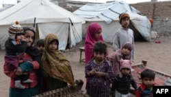 Internally displaced Afghan children gather near their tent on the outskirts of Jalalabad. 