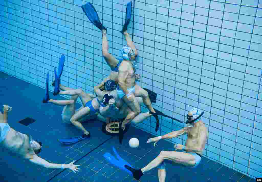 Swimmers play underwater rugby in a public swimming pool at the Olympic Stadium in Berlin on July 29. (epa/Lukas Schulze)