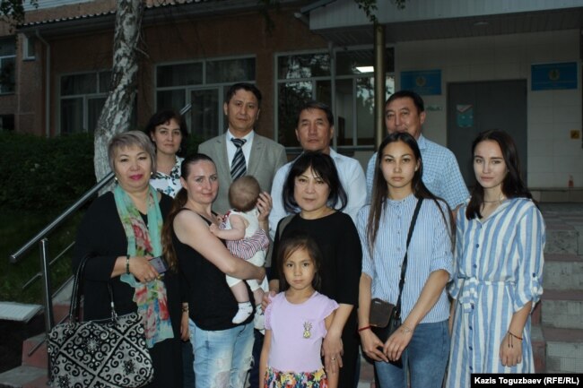 Люди, пришедшие поддержать Оксану Шевчук (c ребенком) и Жазиру Демеуову (третья внизу слева), – на территории следственного суда поздним вечером в Алматы, 31 мая 2019 года.