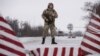 A Ukrainian guard stands ready at the border in Milove.