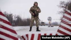 A Ukrainian guard stands ready at the border in Milove.