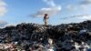 Myanmar - A man walks on the top of the huge dump as he looks for fire-wood outside Yangon, Myanmar June 6, 2017. 