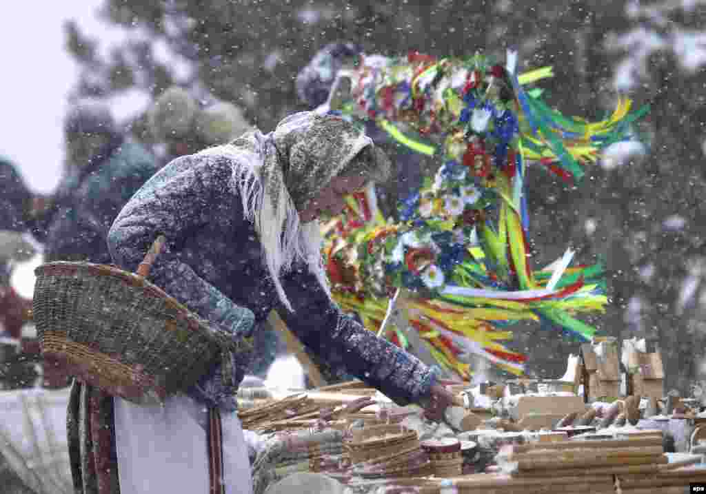 A woman chooses a wooden gift at the open-air market during Maslenitsa celebrations near Minsk, Belarus. &nbsp;