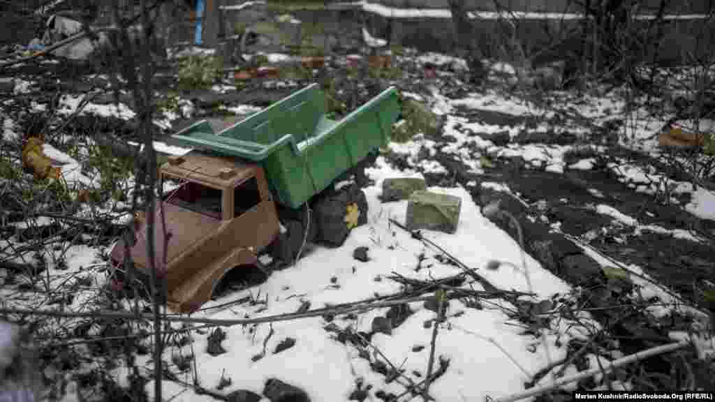 Стахановець (Золоте-3). Дитяча іграшка нагадує зруйновану в мініатюрі техніку, яка подекуди залишається на лінії зіткнення. Ця іграшка, як і безліч дитячого мотлоху навколо, нагадує зруйноване чиєсь дитинство