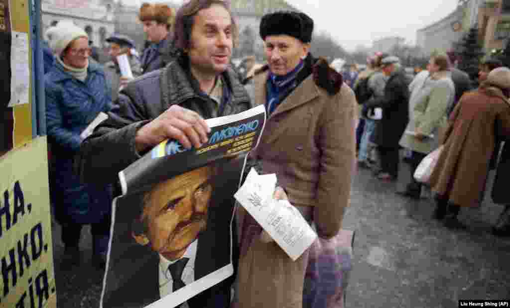 A supporter carries a campaign poster for former dissident Lukyanenko,&nbsp;now a presidential candidate, in Kyiv.