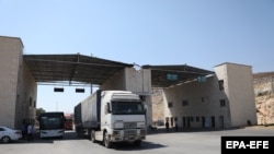 Trucks carry humanitarian aid cross from Turkey into Syria at the Bab al-Hawa border point. 