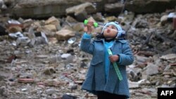 Сирийская девочка среди развалин пускает мыльные пузыри, январь 2017, юг Сирии