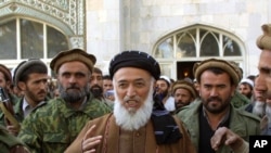 Burhanuddin Rabbani (center) emerges from a mosque surrounded by bodyguards in Kabul last year. 