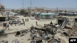 Afghan security personnel keep watch at the scene of the July 15 suicide attack in Orgun district, Paktika province, July 16, 2014.