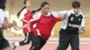 Shamila Kohestani (center) fights for the ball against a Pakistani player during a tournament held by Pakistan's national women's soccer league in Islamabad (file photo)