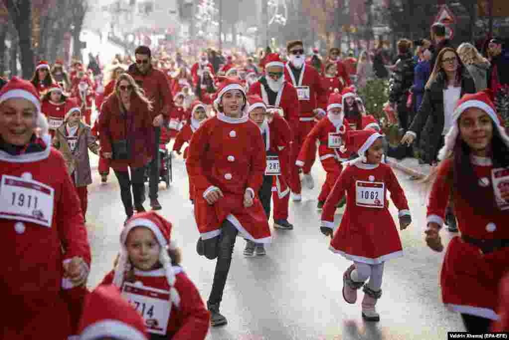 Participants wearing Santa Claus costumes take part in a charity run in Pristina, Kosovo. (epa-EFE/Valdrin Xhemaj)