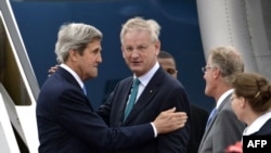 U.S. Secretary of State John Kerry (left) speaks with Swedish Foreign Minister Carl Bildt (center) as he arrives in Stockholm.