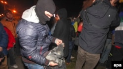 A protester holds Lenin's nose.