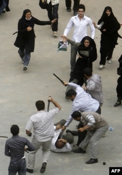 Iran -- Iranian plain clothes policemen beat a demonstrator with batons during a protest against the election results in Tehran on 14Jun2009