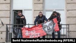 Станислав Асеев снимает баннер, висевший на балконе редакции издании "Украинская неделя". 2 января этого года