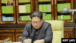 Kim Jong Un într-o secvență de televiziune semnînd autorizarea ultimului test cu o rachetă intercontinentală