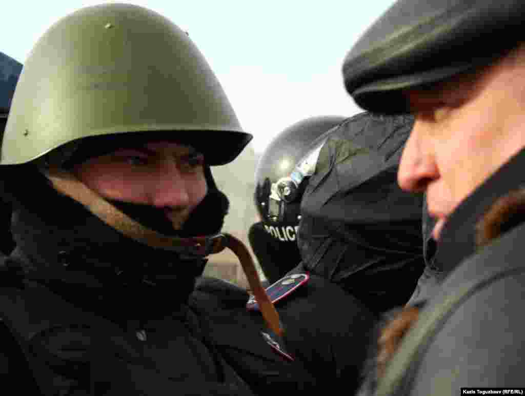Тіркелмеген "Алға" партиясының жетекшісі Владимир Козлов орталық алаңда полиция қызметкерімен сөйлесуге тырысып тұр. Ақтау, 21 желтоқсан 2011 жыл