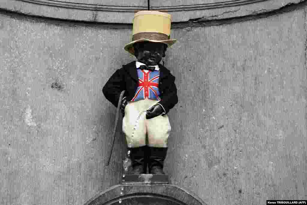 A picture taken on January 30 shows Brussels' landmark Manneken-Pis statue decorated with a Union Jack waistcoat and a top hat to mark the departure of the United Kingdom from the European Union. (AFP/Kenzo Tribouillard)