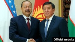 Kyrgyz Prime Minister Sooronbai Jeenbekov (right) welcomes Uzbek Prime Minister Abdulla Aripov to Bishkek on August 16.