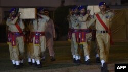 Pakistani soldiers carry the coffins of military policemen during their funeral in Karachi on December 1 following an attack by gunmen.