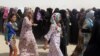 Displaced Iraqi families fleeing Fallujah queue for food rations and other emergency supplies at an aid camp outside Baghdad.