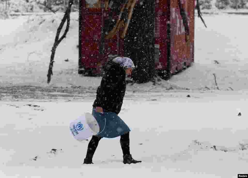 A Syrian woman braves a snowstorm at a refugee camp north of Athens, Greece, on January 10. (Reuters/Yannis Behrakis)