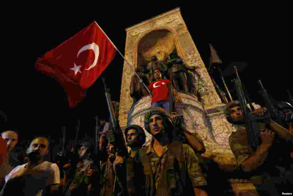 Members of the Turkish military are posted on Taksim Square in Istanbul as civilians wave Turkish flags.