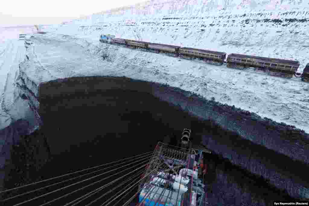 A coal train moves along coal beds as a rotary dredge excavates coal at Russia&#39;s Borodinsky opencast colliery, near the Siberian town of Borodino, in the Krasnoyarsk region of Russia. (Reuters/Ilya Naymushin)