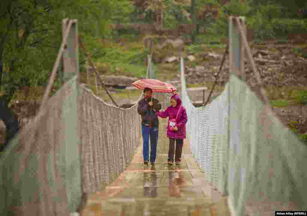 A mother and daughter cross one of Borhomi&#39;s suspension bridges.