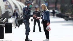 Armenia -- A police officer checks documents of a woman in Yerevan as part of a coronavirus lockdown imposed by the government, March 25, 2020.