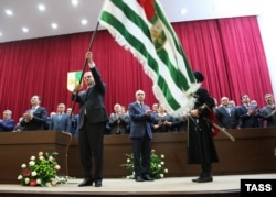 Президент болып сайланған Рауль Хаджимба инаугурациясы кезінде Абхазия туын көтеріп ұстап тұр. Сухуми, 25 қыркүйек 2014 жыл.