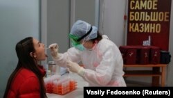 BELARUS -- A nurse wearing protective gear takes a swab from a passenger, who arrived from the Egyptian resort of Sharm el-Sheikh, during a coronavirus disease (COVID-19) test at the Minsk National Airport, March 19, 2020