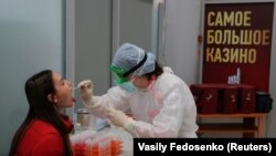 O asistentă efectuează un test pentru depistarea infecției cu coronavirus