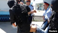 Полицейские тащат парня недалеко от площади Республики в Алматы. 21 мая 2016 года.
