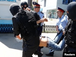 Kazakh riot police officers detain a demonstrator during a protest against land reforms in May 2016.