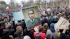 Protesters carry a poster depicting President Vladimir Putin as an elderly Soviet leader in St. Petersburg on May 5.