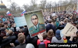 Anti-Putin demonstrators carry a poster drawing a comparison between the Russian president and the elderly Soviet Communist leader Leonid Brezhnev during a protest rally in St. Petersburg on May 5.