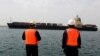 Iran - Workers watch a ship as it sails during an inauguration ceremony of new equipment and infrastructure at Shahid Beheshti Port in the coastal city of Chabahar, February 25, 2019.