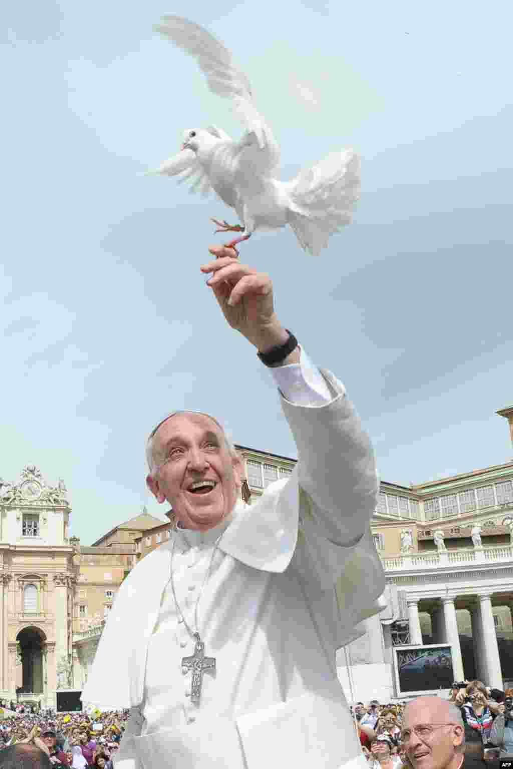Pope Francis lets a white dove fly in front of pilgrims following his weekly general audience in St. Peter's Square at the Vatican. (AFP/Osservatore Romano)