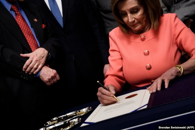 Udhëheqësja e Dhomës së Përfaqësuesve, Nancy Pelosi duke nënshkruar artikujt për shkarkim të Trumpit.