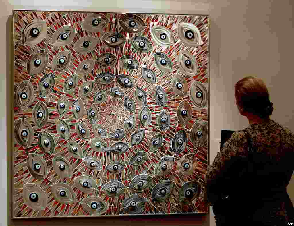 A woman admires an painting by Iranian artists Mounir Farmanfarmaian at an exhibition set by Christie's auction house in Dubai on April 26, 2009. (Photo by MARWAN NAAMANI / AFP)