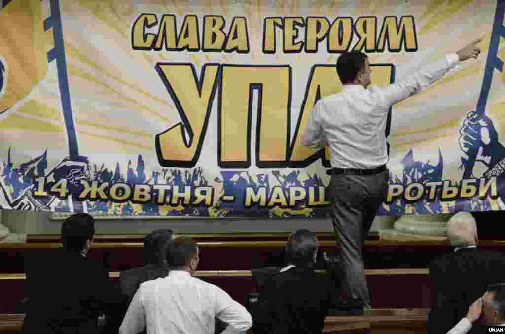 Народні депутати від фракції ВО «Свобода» розвішують банер із символікою УПА у Верховній Раді. На знак протесту фракції Партії регіонів і КПУ залишили сесійну залу. Київ, 11 жовтня 2013 року.